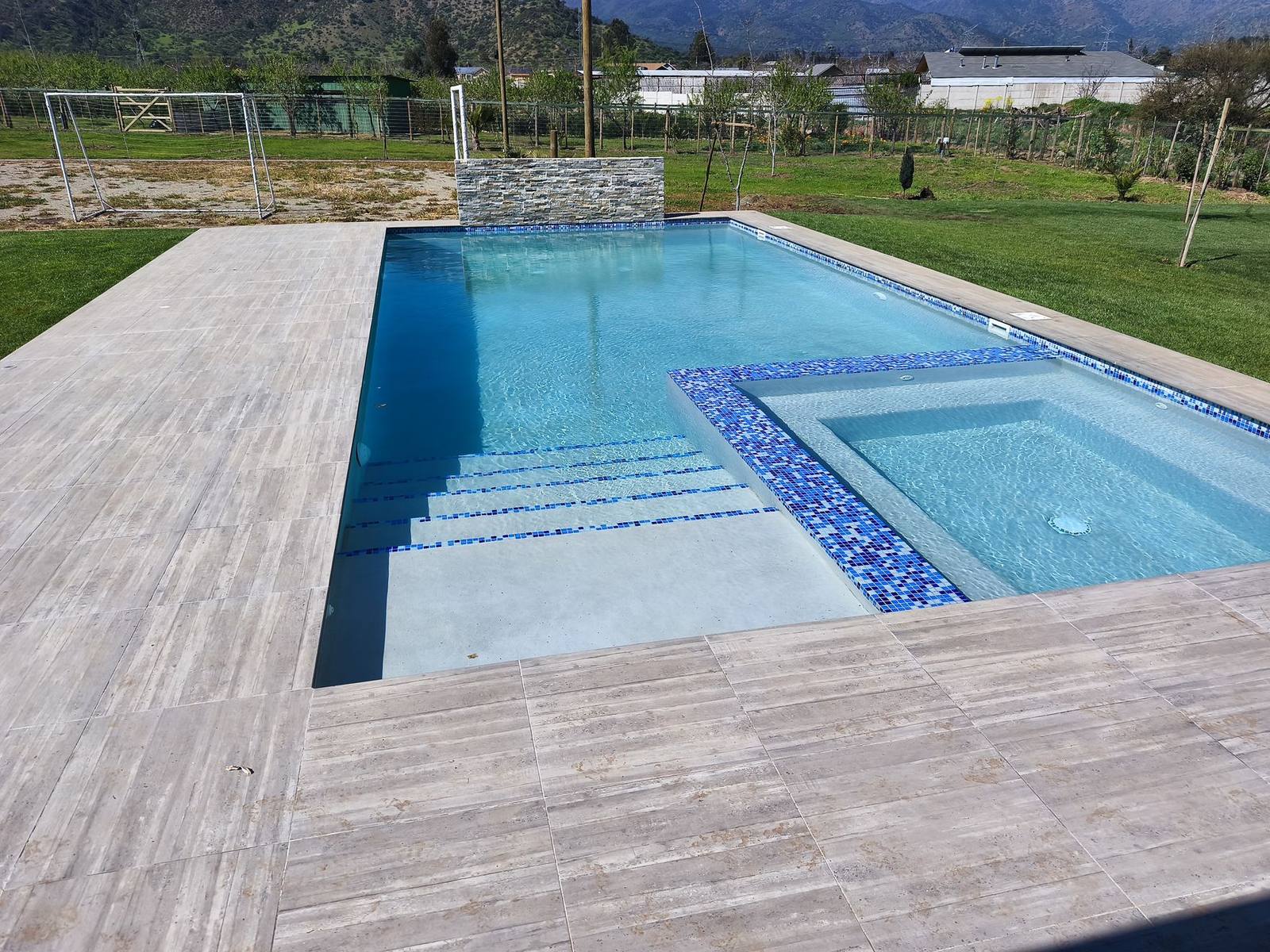 Piscina de hormigón con spa y deck