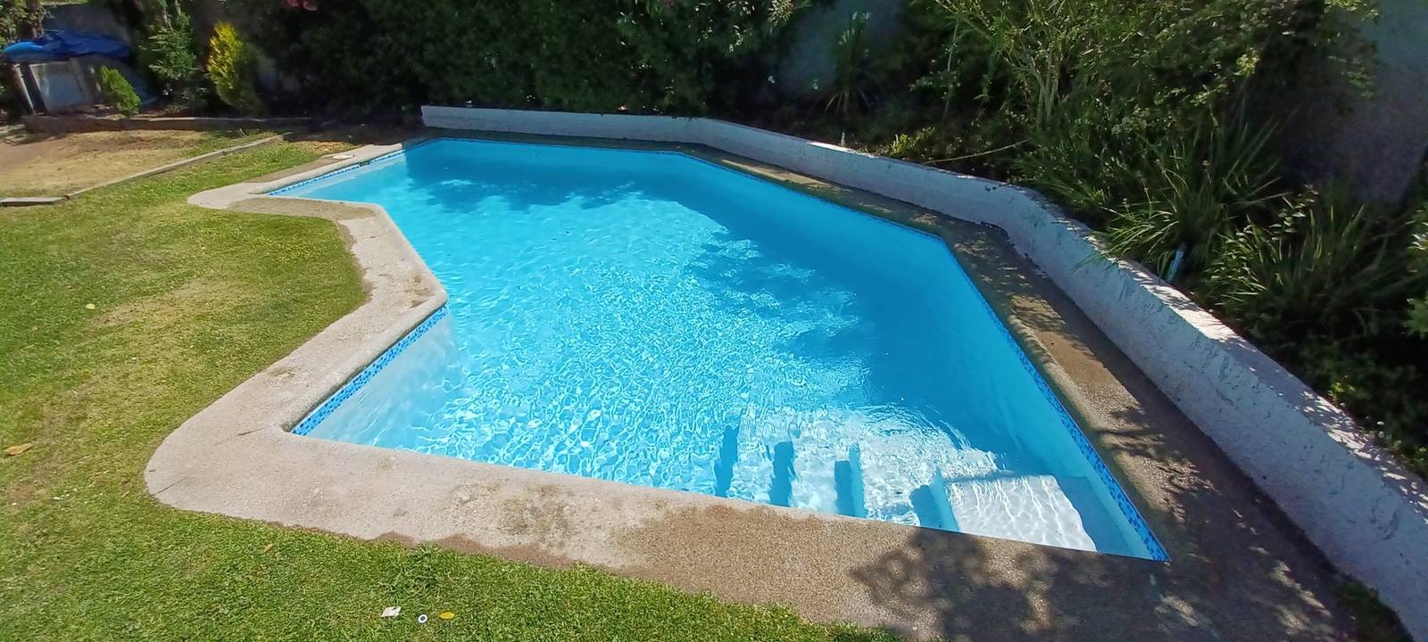 Piscina de forma libre con escalera